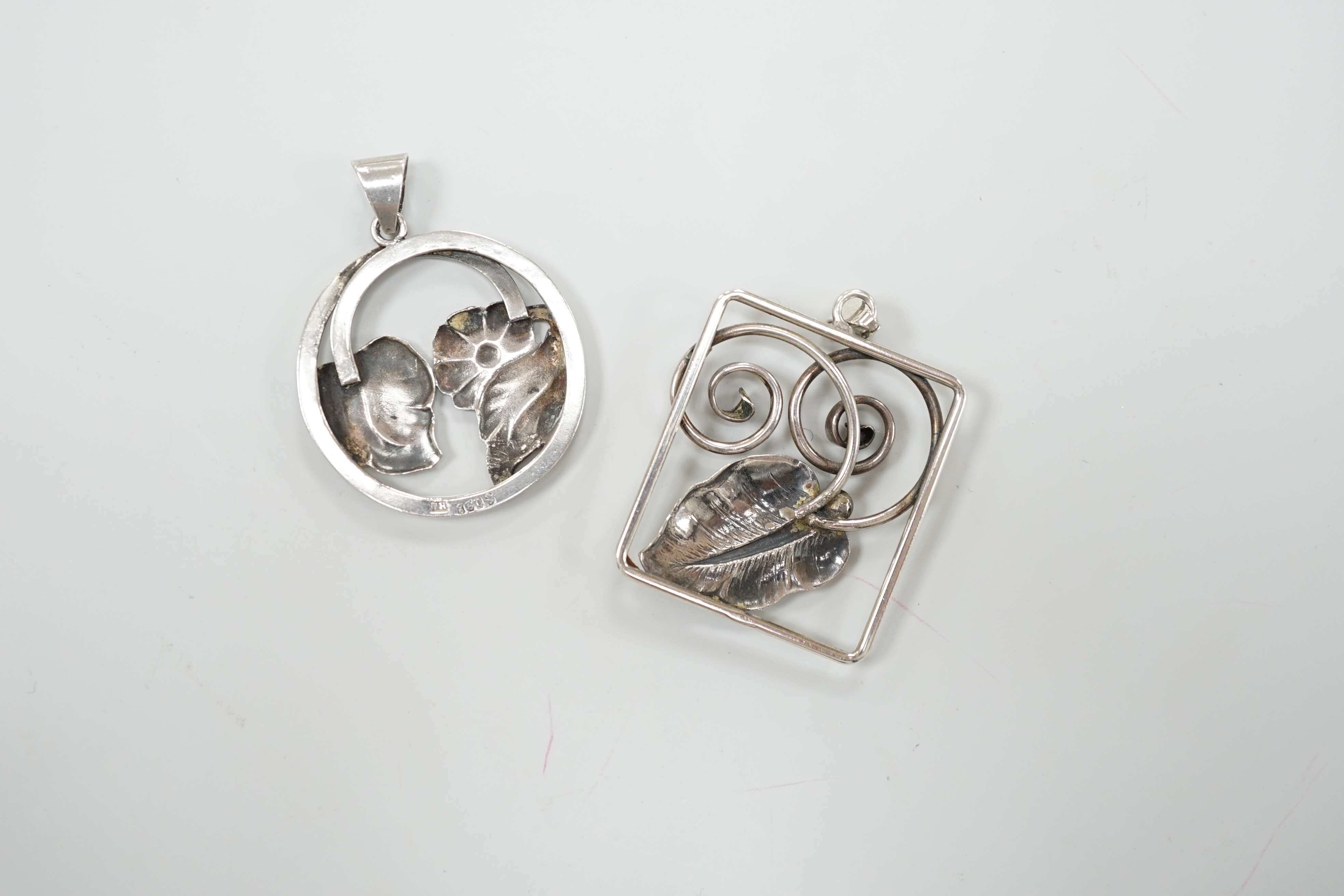 Two 1930's Danish 830 standard white metal pendants, leaf and daisy design, by Bernard Hertz, 4.25cm and leaf and tendril design by Jorgen Christiansen, 4.5cm